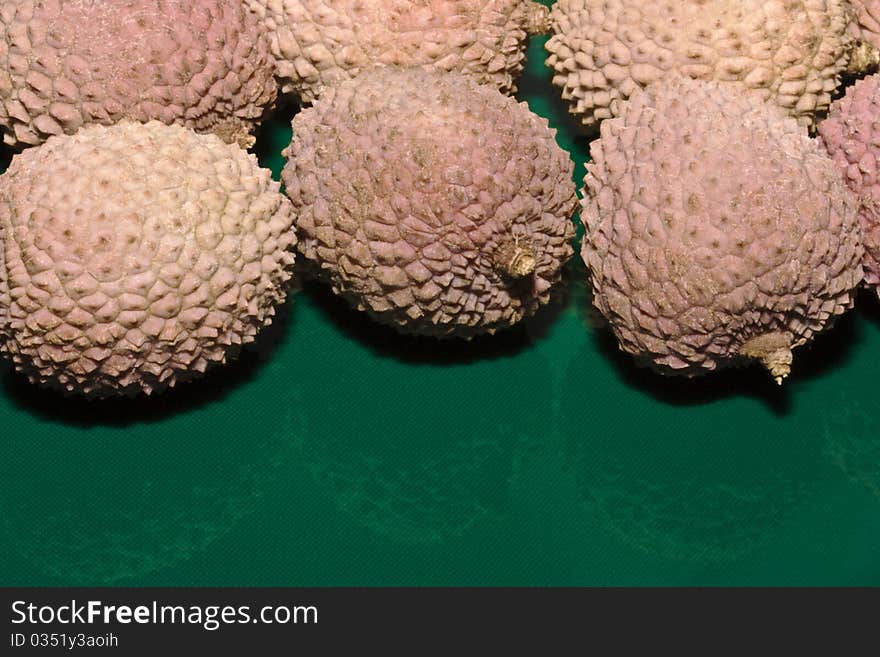 A close up of lychee fruit on a green background