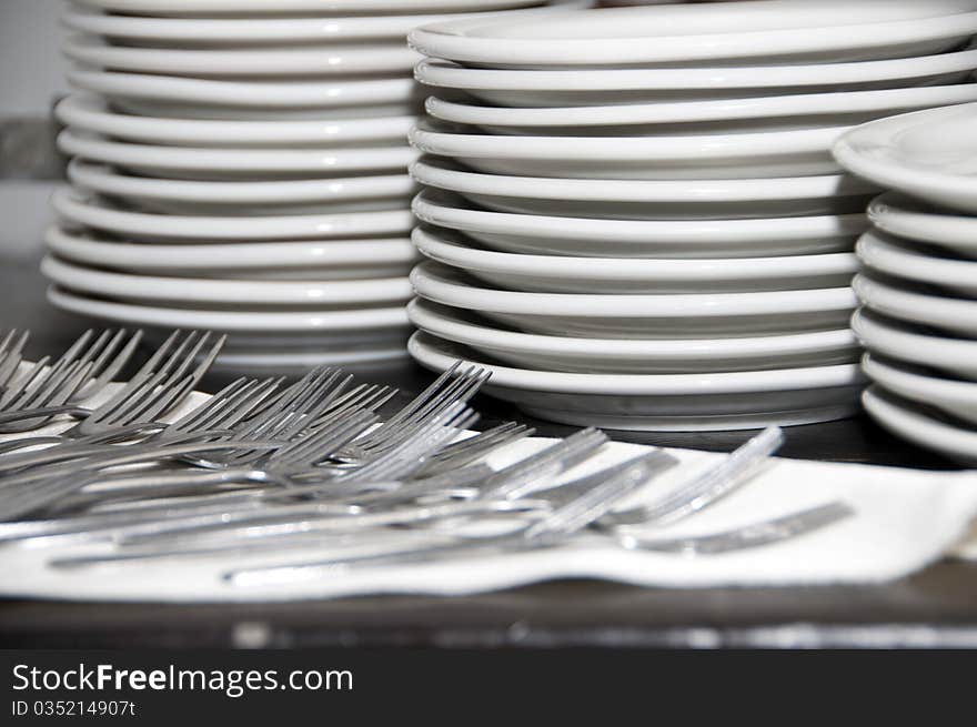 Plates forks on the table before distribution. Plates forks on the table before distribution