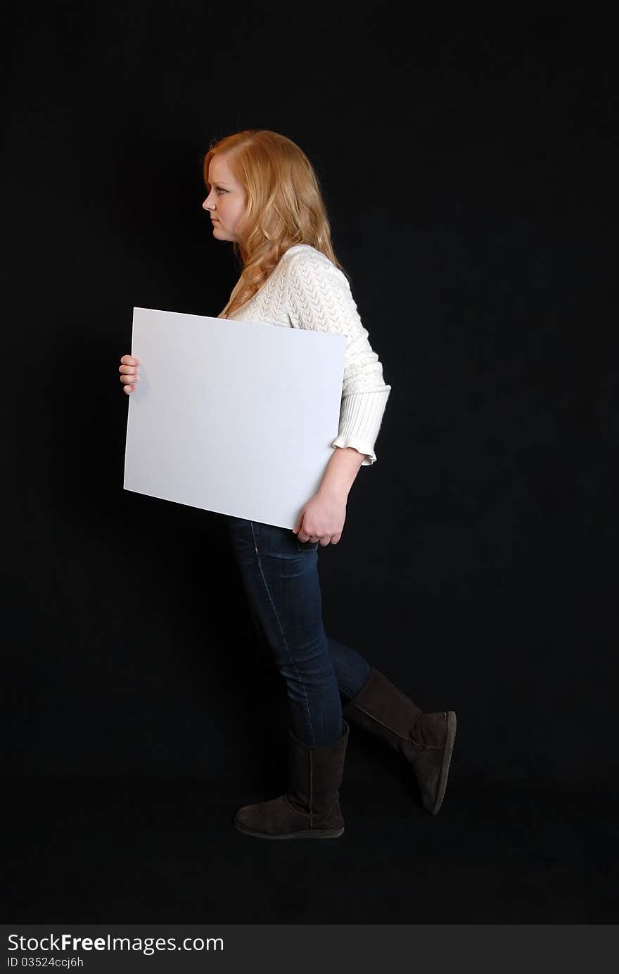 Woman carrying blank white placard sign. Woman carrying blank white placard sign.