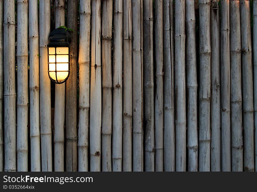 Yellow lamp on the bamboo fence in front of the resort in Thailand