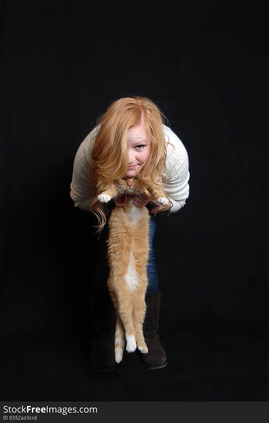 Red haired woman holding pet cat with same hair color. Red haired woman holding pet cat with same hair color