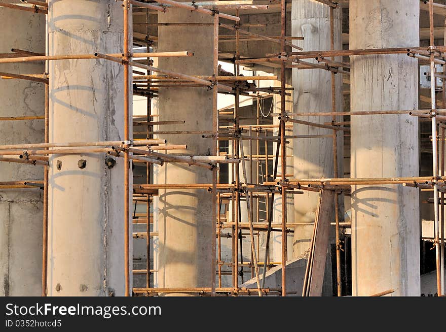 Scaffold and unfinshed poles in depth view, in big construction working area. Scaffold and unfinshed poles in depth view, in big construction working area.