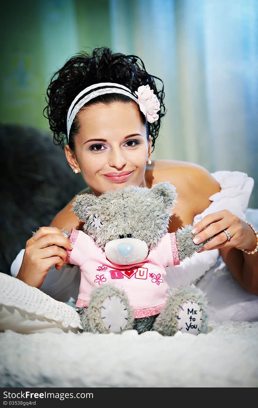 Portrait beautiful bride with teddy bear on white bed in wedding day. Portrait beautiful bride with teddy bear on white bed in wedding day