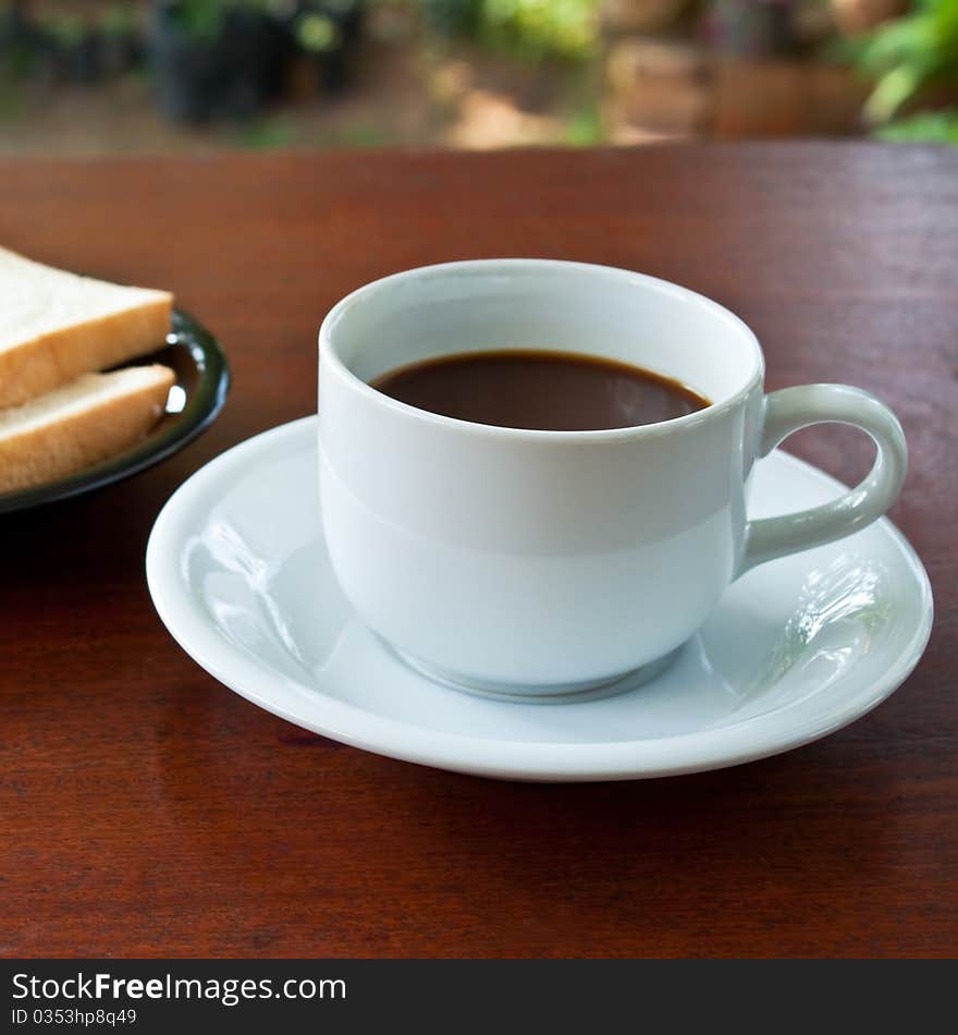 Cup of coffee and bread on table