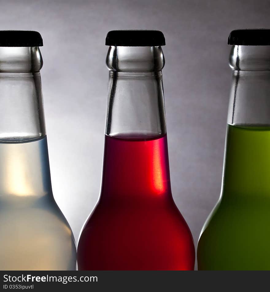 Three colorful bottle of drink on light background