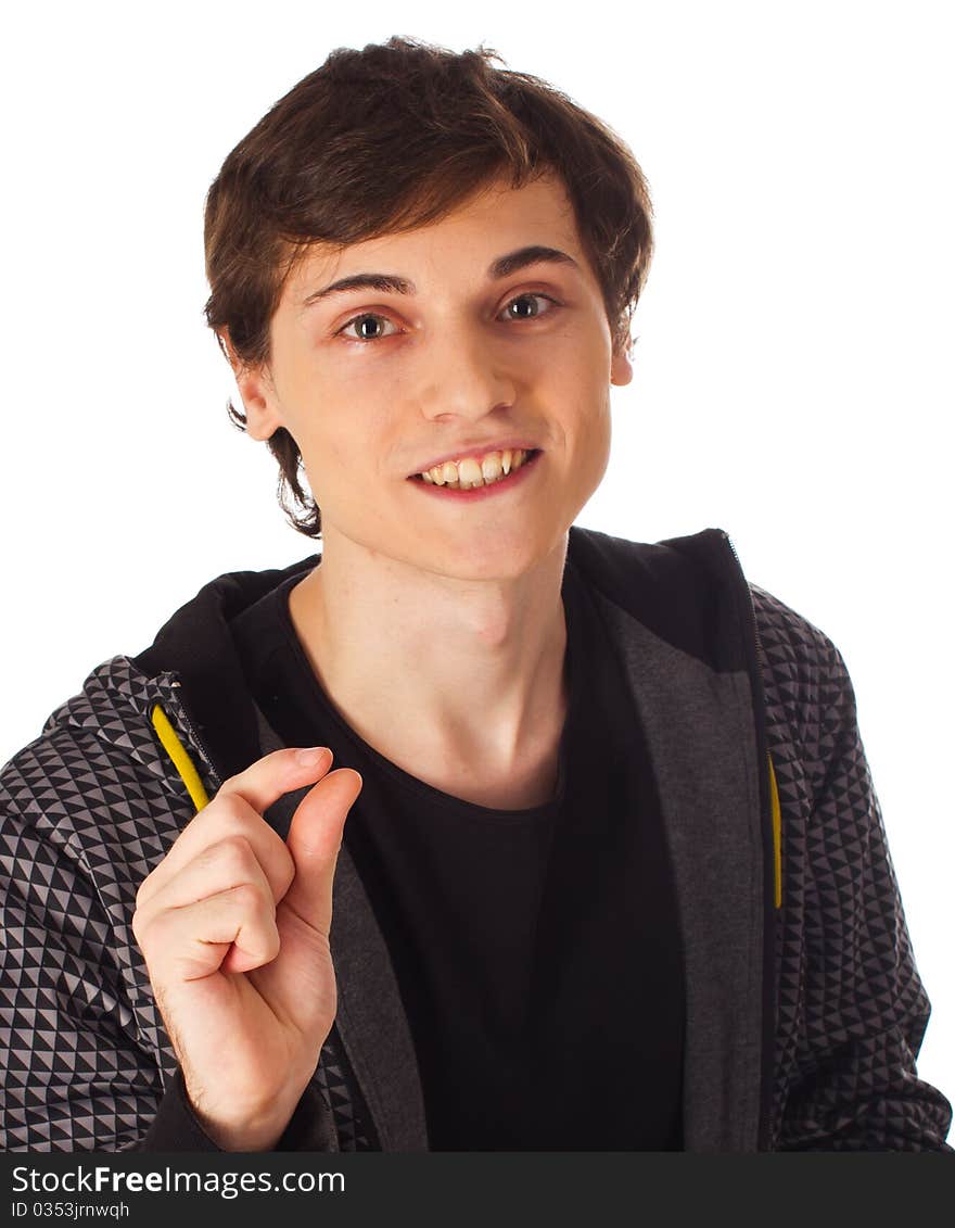 Young man standing on white background and showing 'just a little bit' with his fingers