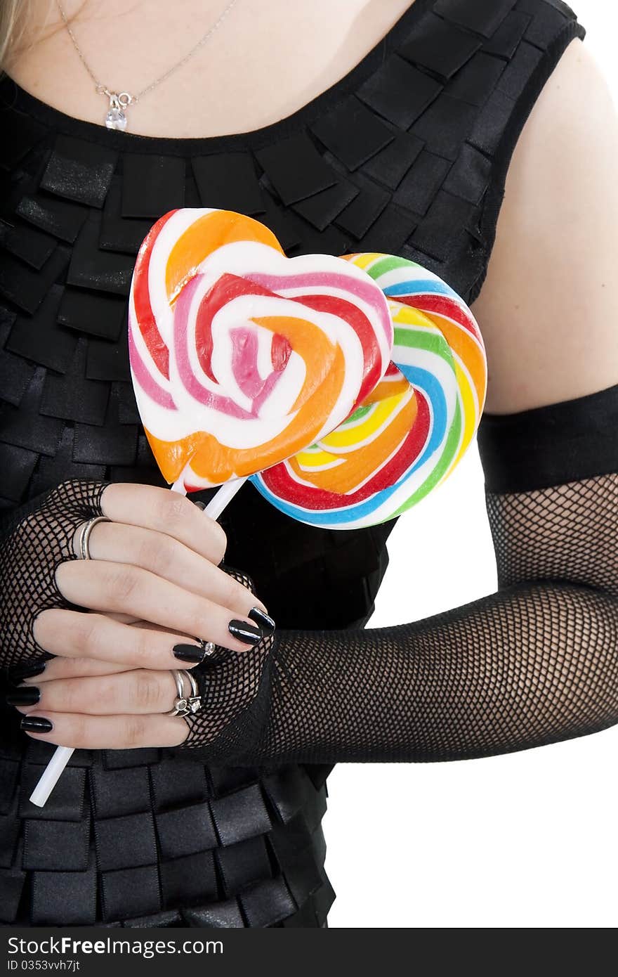 The young girl in black dress is holding a lollypops. The young girl in black dress is holding a lollypops