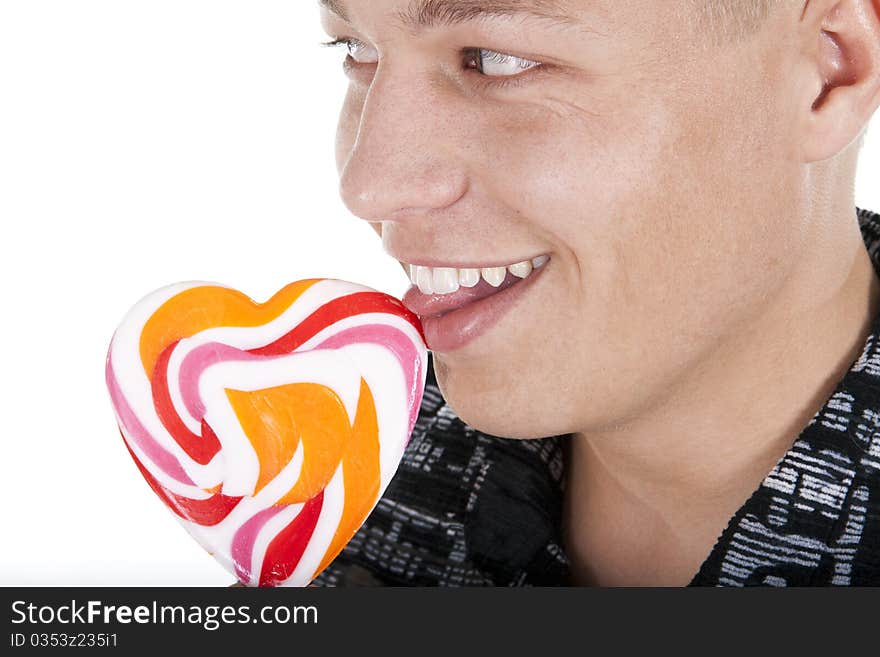 The young man is licking a lollypop