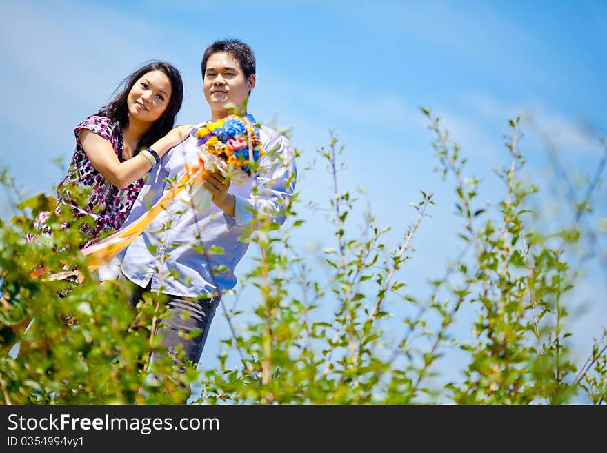 Romantic couples standing outdoors with flowers bouquet