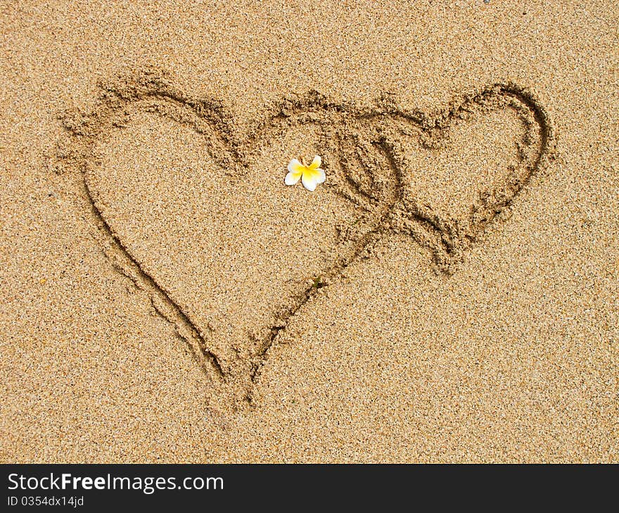 Two connected hearts drawn on wet sand. Two connected hearts drawn on wet sand