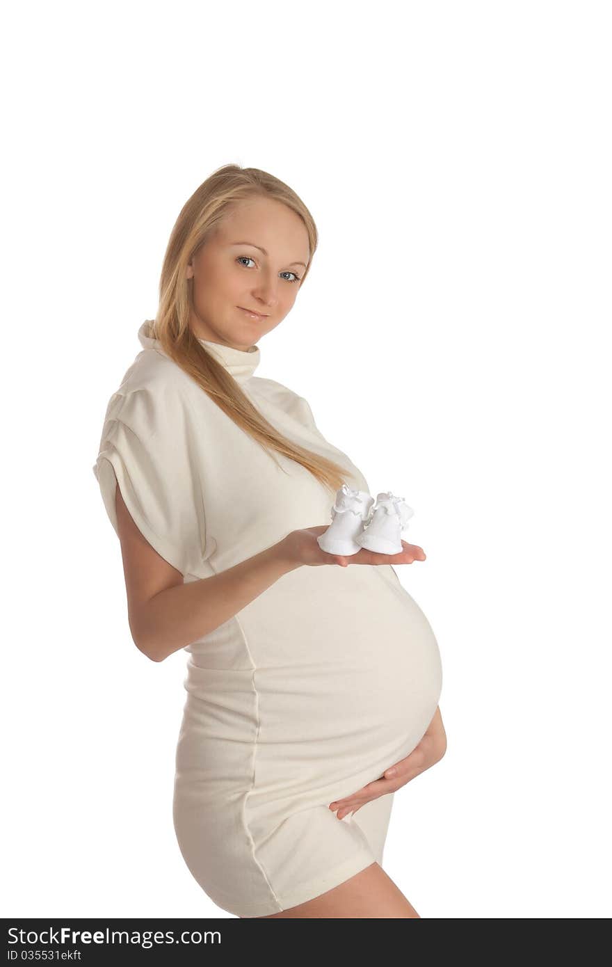 Pregnant young woman, holding baby's bootees. Pregnant young woman, holding baby's bootees.