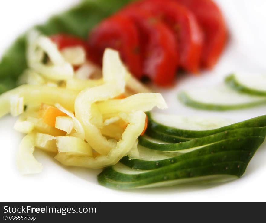 Vegetable mix of chopped peppers, cucumbers and tomatoes on a plate. Vegetable mix of chopped peppers, cucumbers and tomatoes on a plate