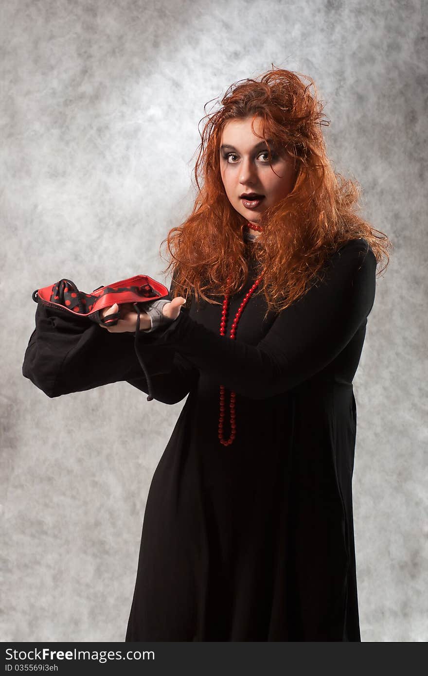 Crazy young woman with tousled hair and an empty bag in his hands