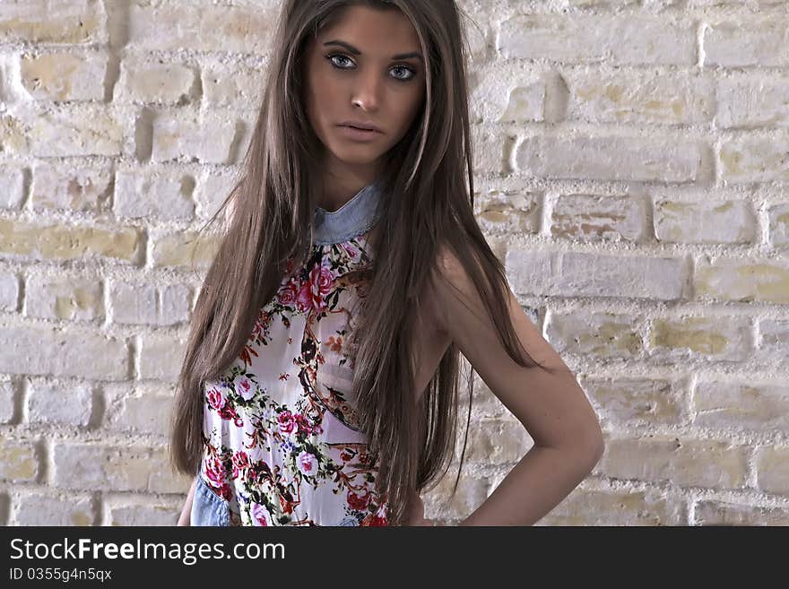 Young sexy woman on brick wall background. Photo.