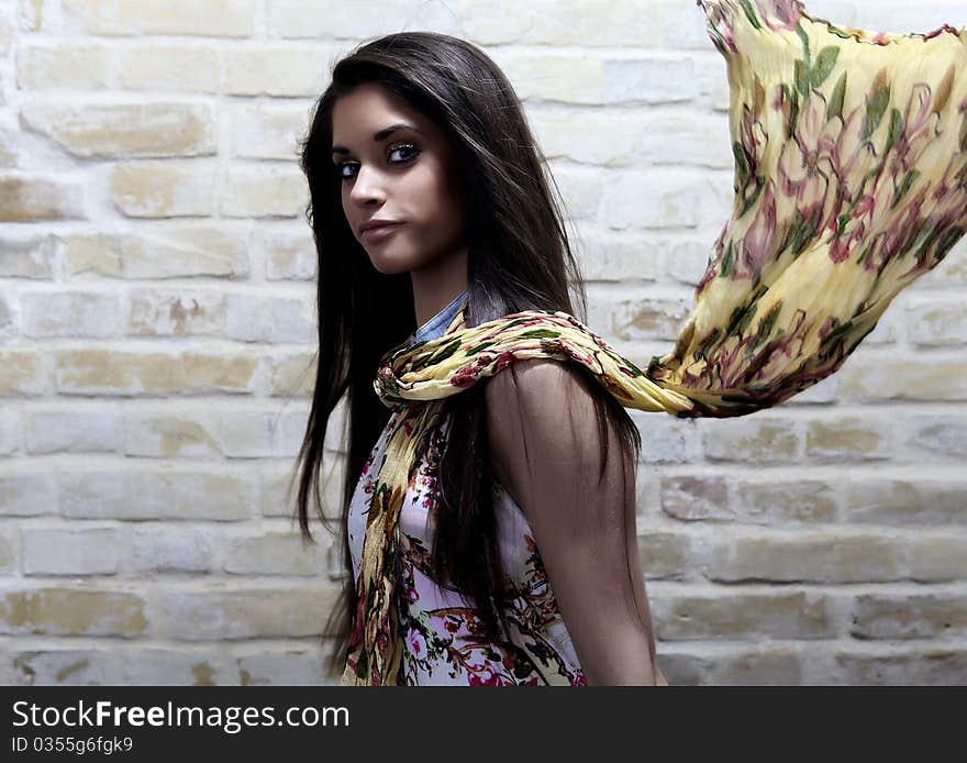 Young sexy woman on brick wall background.