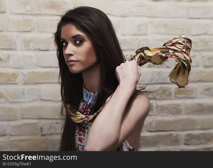 Young sexy woman on brick wall background. Photo.