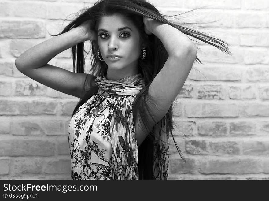 Young sexy woman on brick wall background.