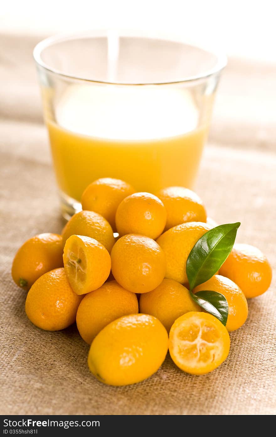 Kumquat small orange fruits on brown background