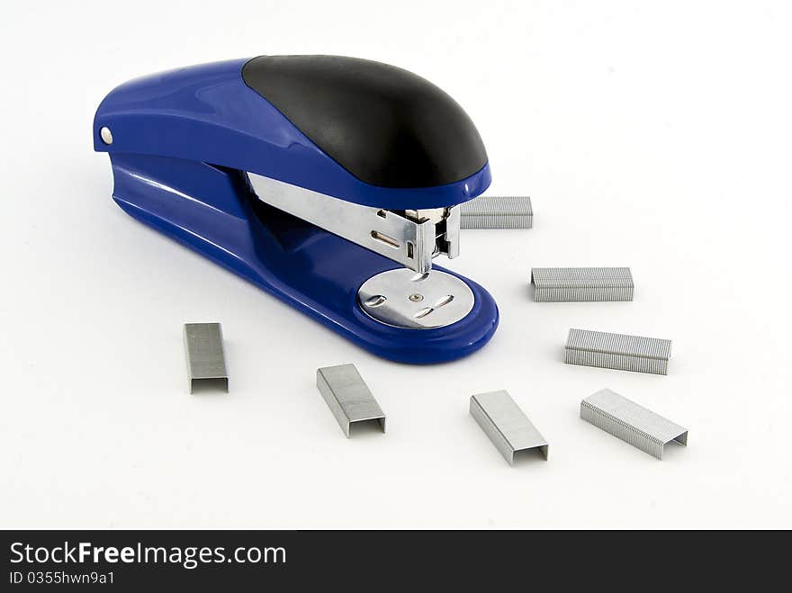 A blue stapler with paper clips on white background