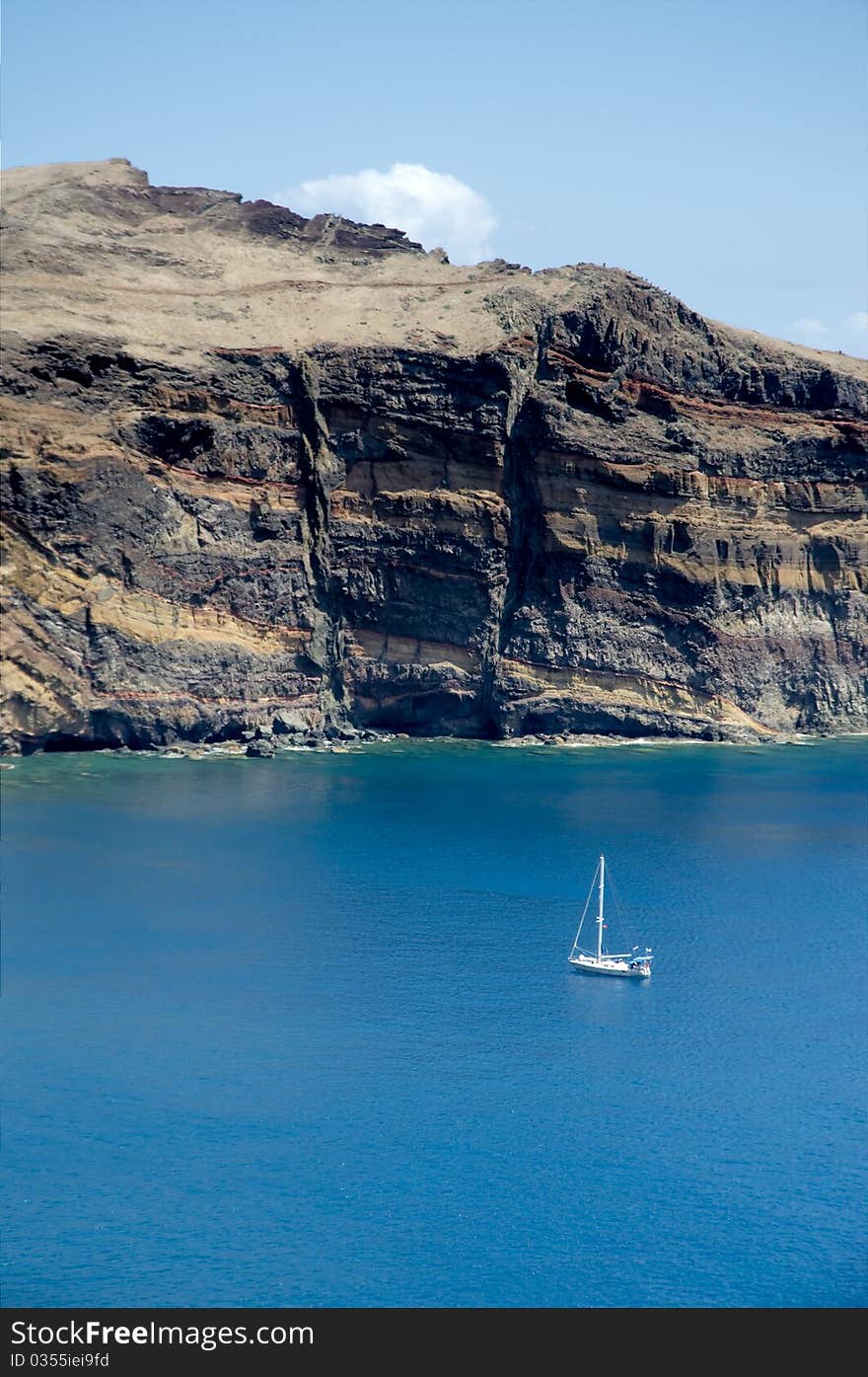 Sailboat anchored near cliff