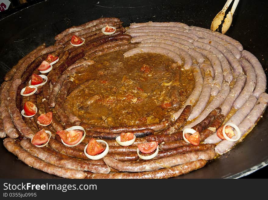 A big sausage in a frying pan. A big sausage in a frying pan