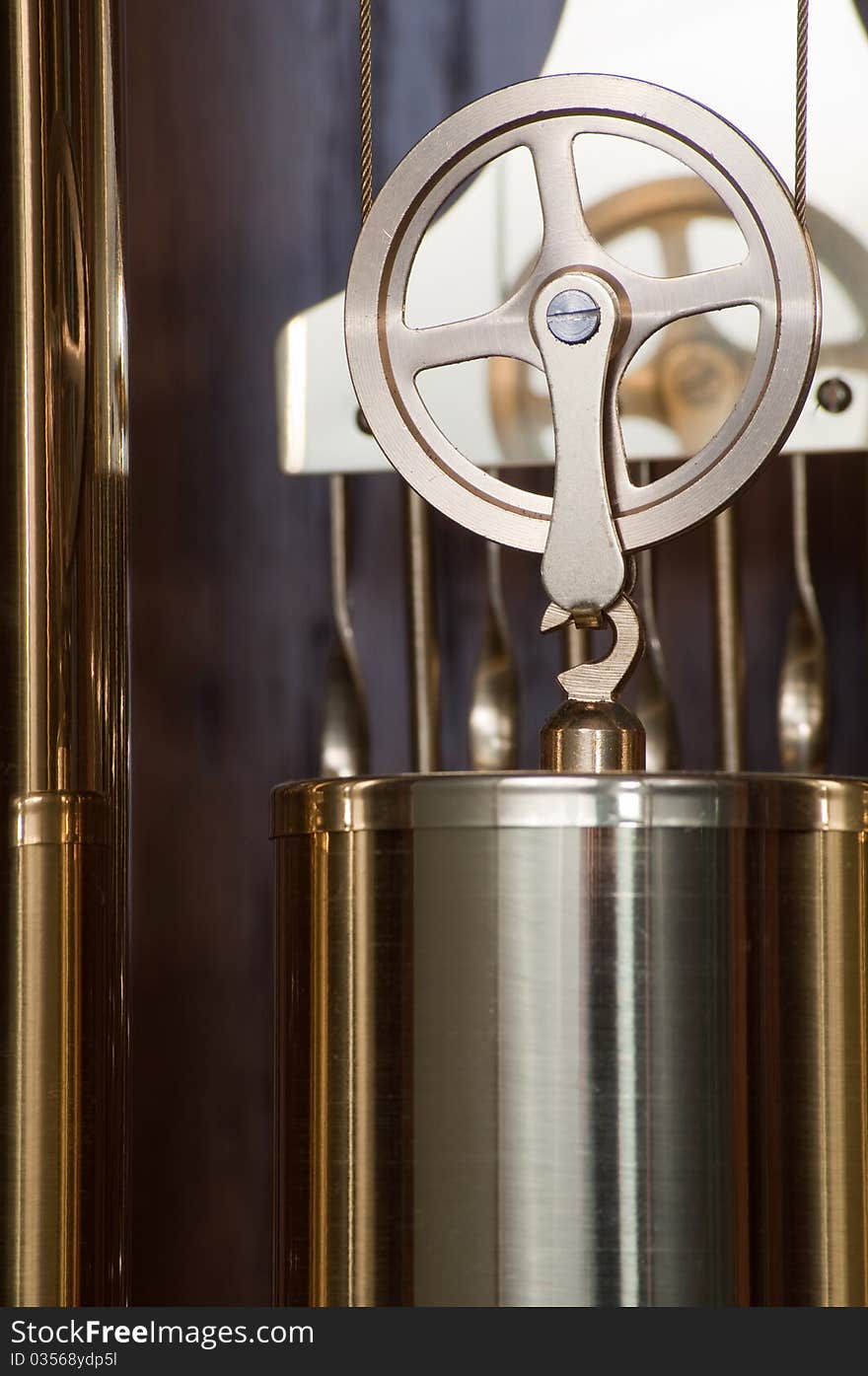 Close-up of shiny brass machined pulley, wheel, and pendulum. Close-up of shiny brass machined pulley, wheel, and pendulum.