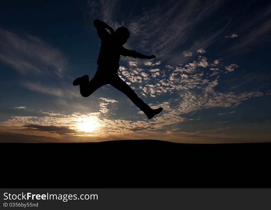 The silhouette of the guy against a decline, the beautiful sky, jumps upwards, a kick. The silhouette of the guy against a decline, the beautiful sky, jumps upwards, a kick