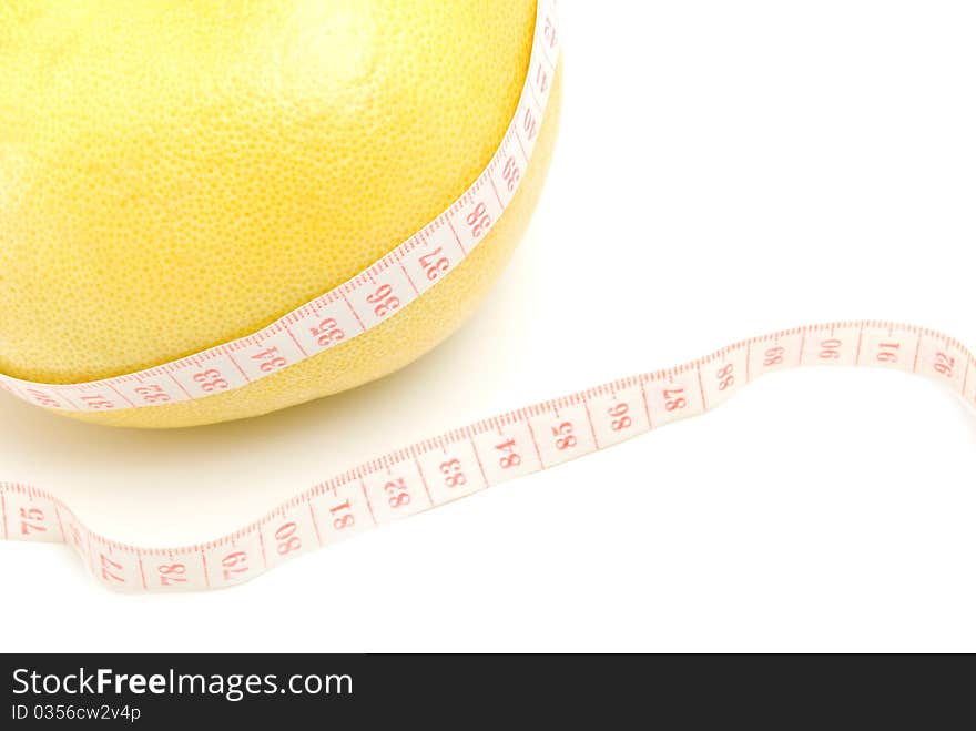 Grapefruit in the measuring tape, is isolated on a white background. Grapefruit in the measuring tape, is isolated on a white background