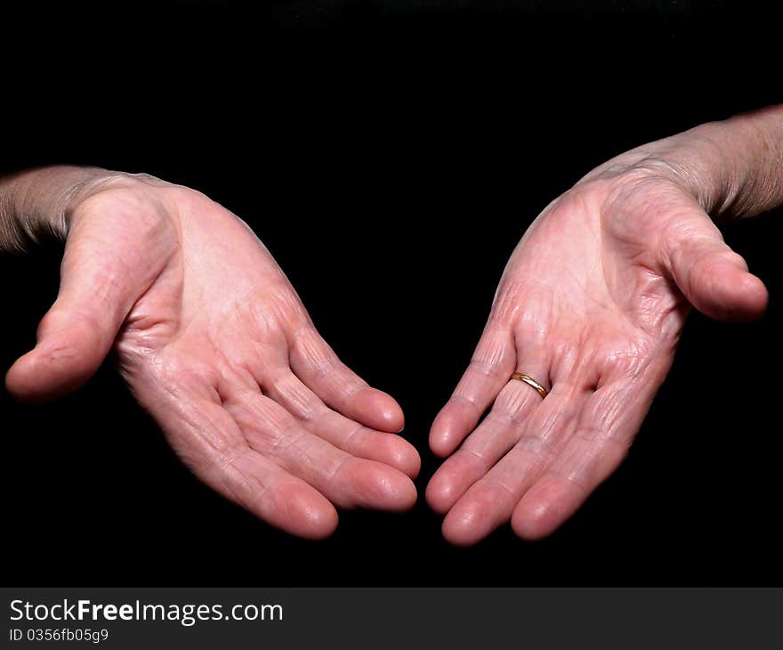 Old woman's hands isolated on black