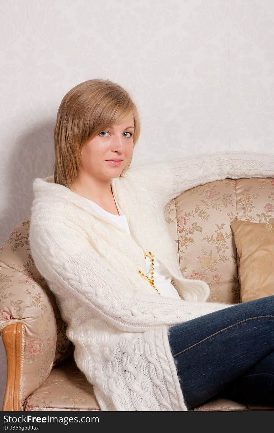 Young woman sits on a sofa