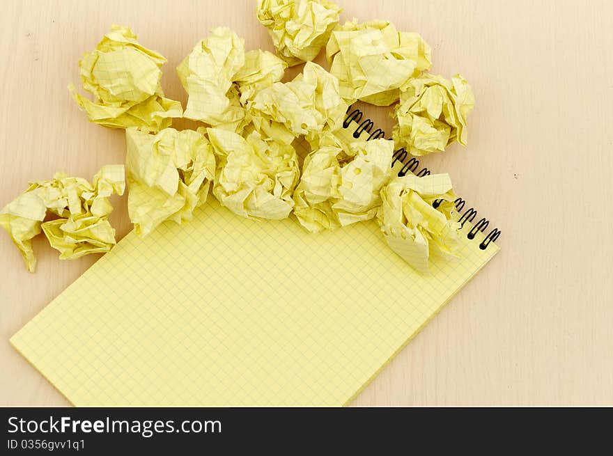 Notebook and crumpled paper on wooden table