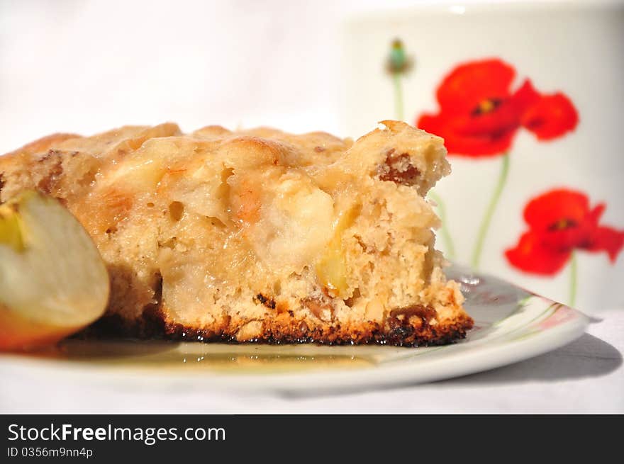 Plate of apple pie with fresh apples with honey and cup of tea