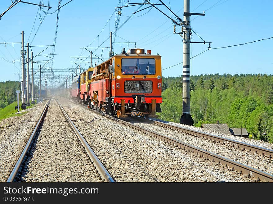 Red-orange trolley does run on railway tracks in the summer