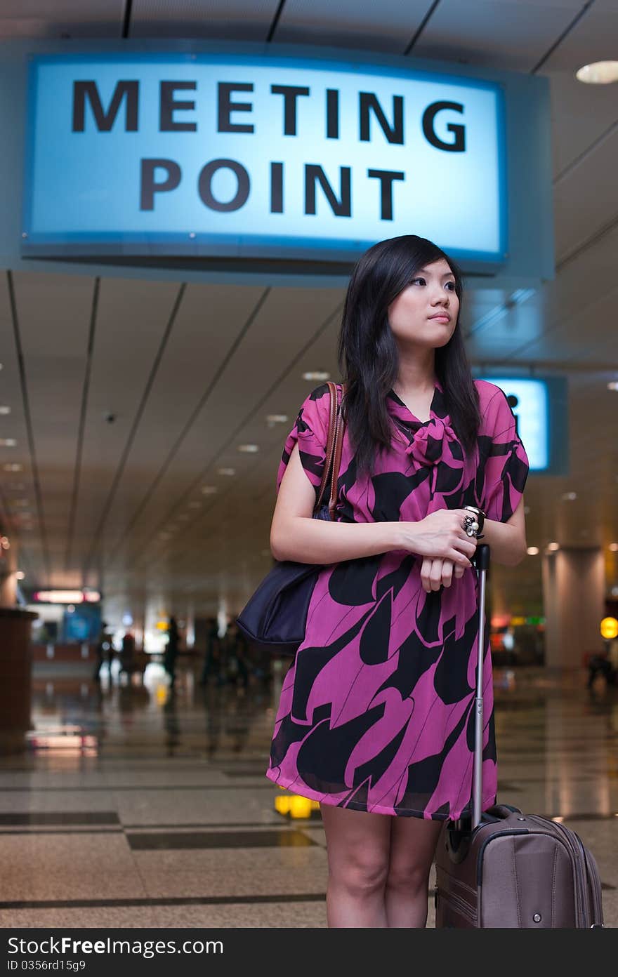 Asian lady waiting for a late comer at the meeting point at the airport. Asian lady waiting for a late comer at the meeting point at the airport