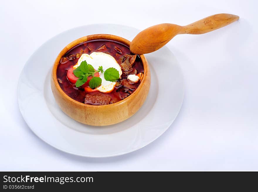 Soup with sour cream in wood plate with spoon. Soup with sour cream in wood plate with spoon