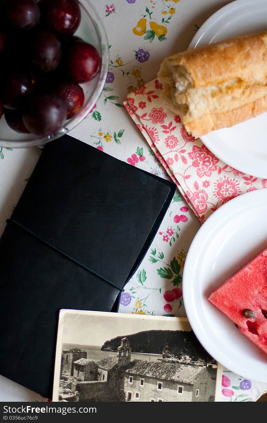 Composition from bread, notebook and plum on the table. Composition from bread, notebook and plum on the table