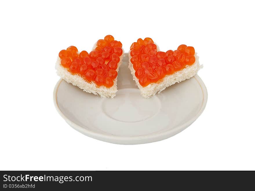 Two pieces of bread in the form of a heart with red caviar on plate on white background. Two pieces of bread in the form of a heart with red caviar on plate on white background