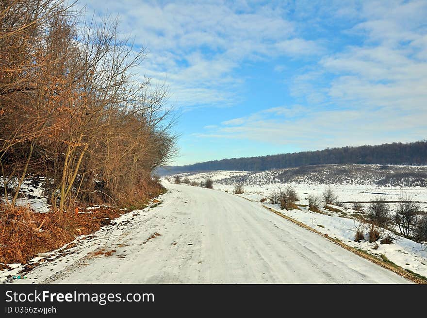 Snowy road near frozen forest