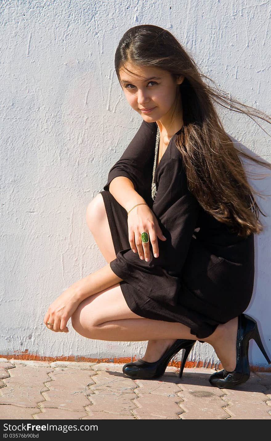 Beautiful Asian girl in brown dress on a background of white stone wall. Beautiful Asian girl in brown dress on a background of white stone wall