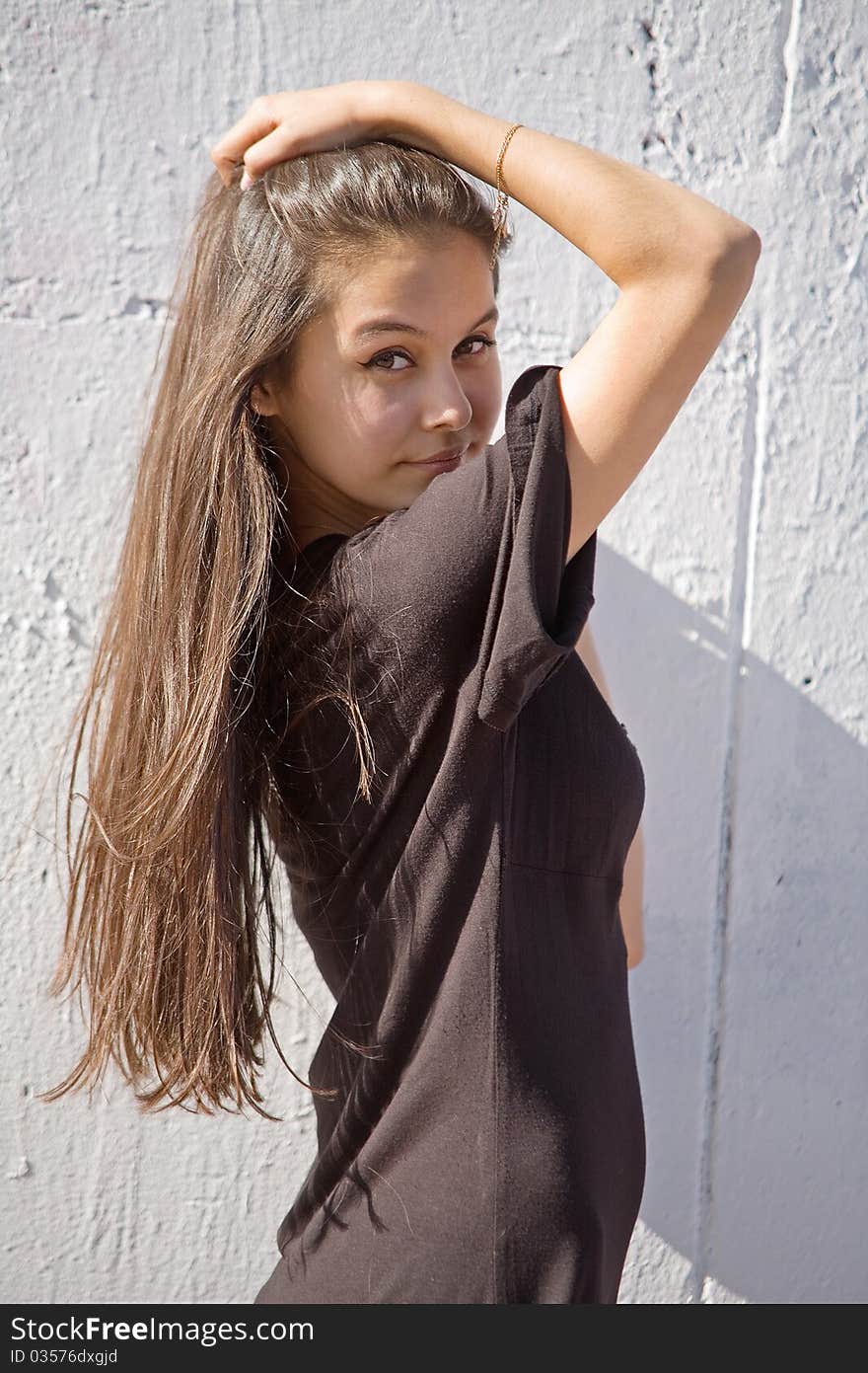 Beautiful Asian girl in brown dress on a background of white stone wall. Beautiful Asian girl in brown dress on a background of white stone wall