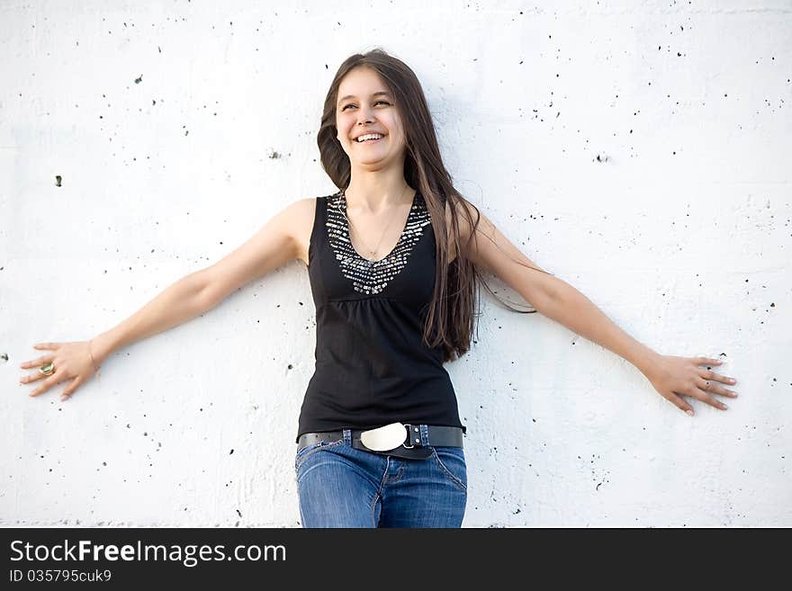 Beautiful Asian girl in jeans on a background of white stone wall