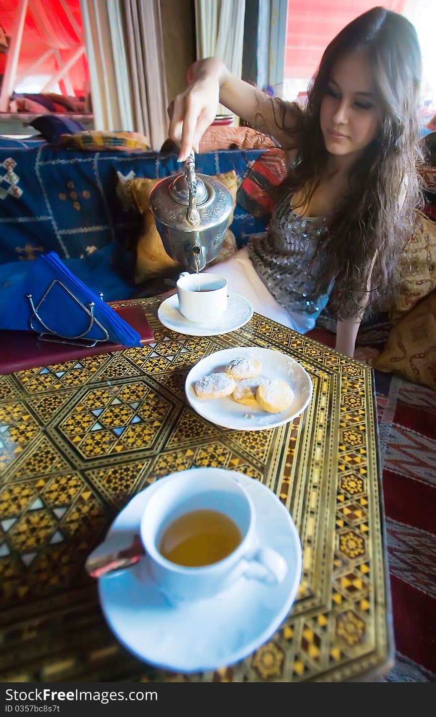 Beautiful Asian girl drinking tea in the national Asian interior