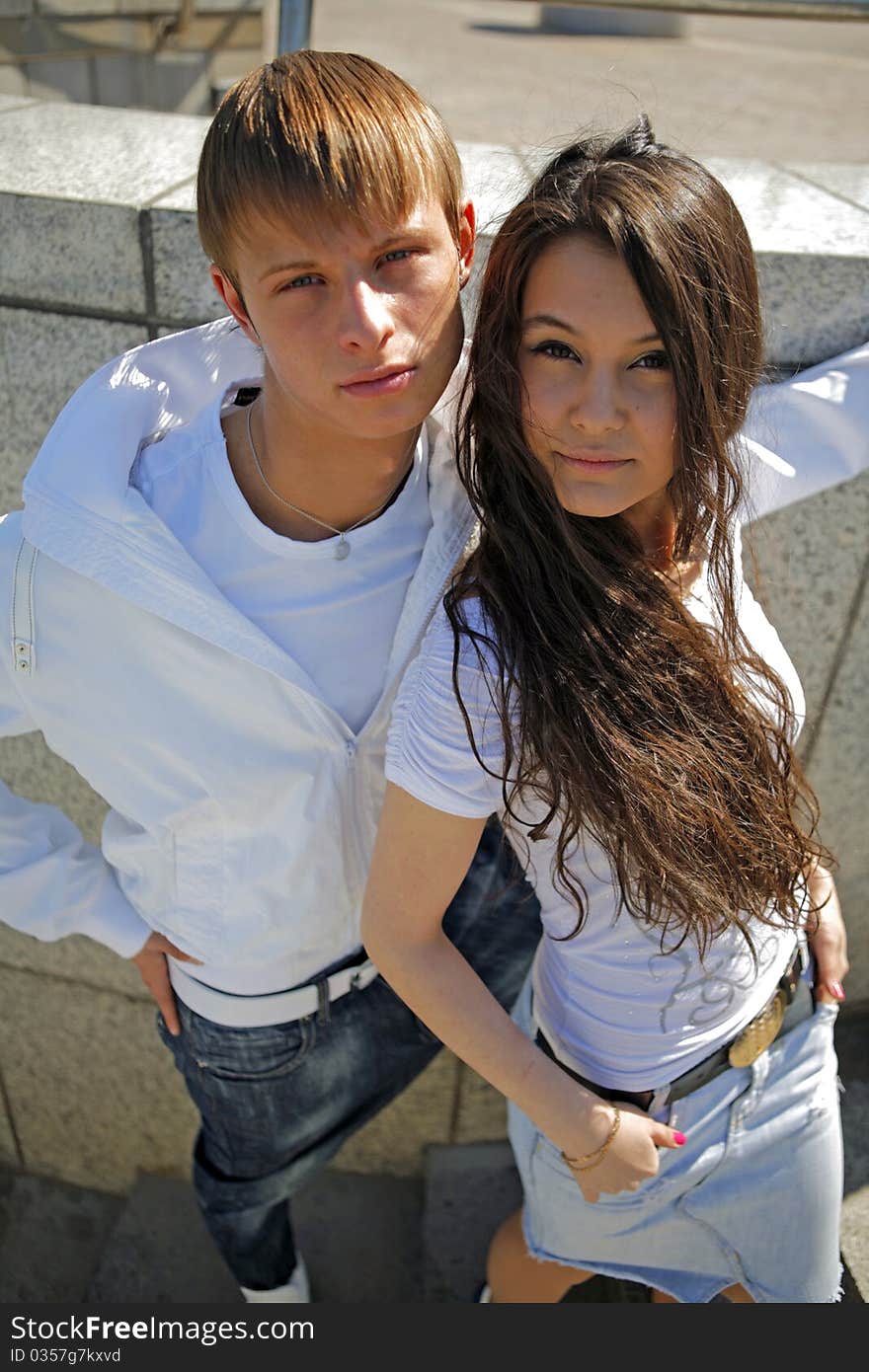 Two fashionable and trendy teenagers against the blue sky and skyscrapers (modern buildings). Two fashionable and trendy teenagers against the blue sky and skyscrapers (modern buildings)