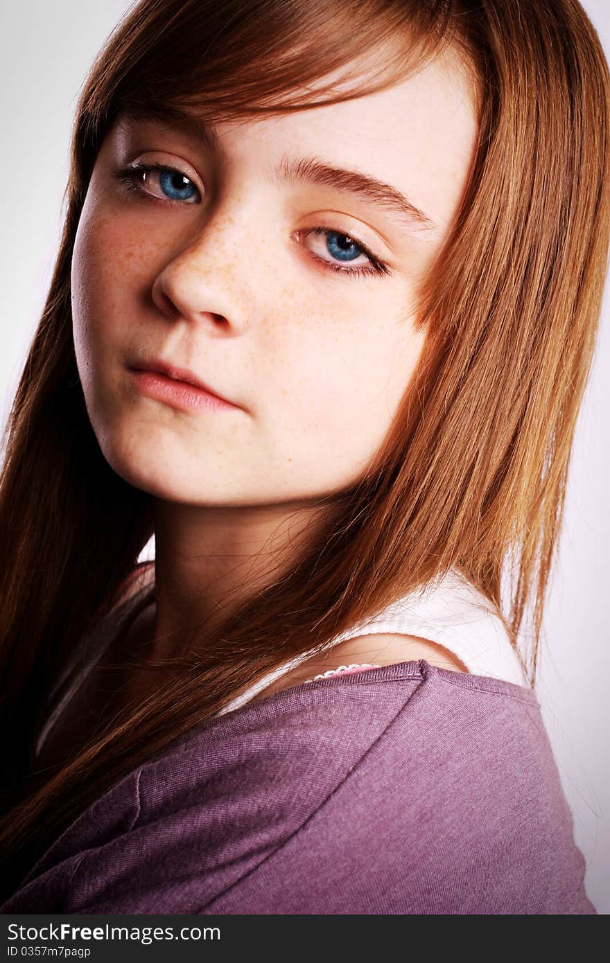 A beautiful young girl looking at the camera on a white background. A beautiful young girl looking at the camera on a white background.