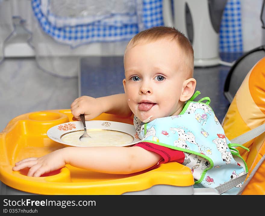 Little kid eating a big milk soup spoon. Little kid eating a big milk soup spoon