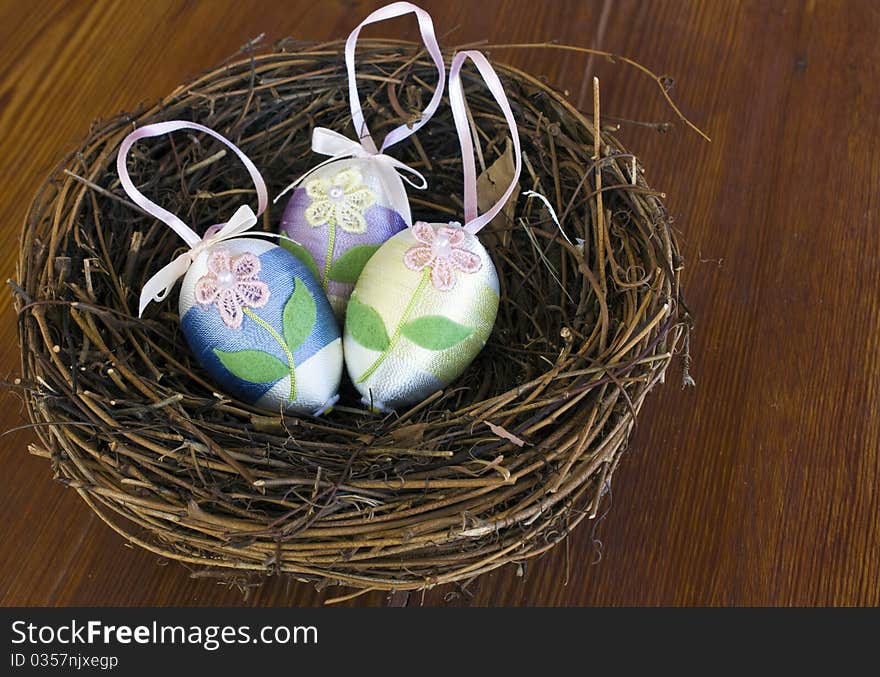 Easter eggs Decorated with yarn in a nest on a wooden table. Easter eggs Decorated with yarn in a nest on a wooden table