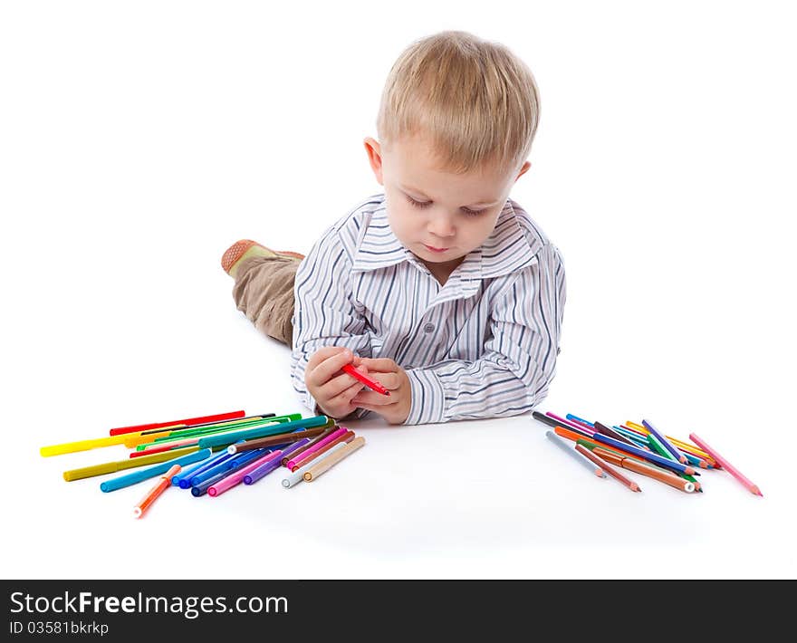 A cute boy with markers and pencils. isolated on a white background