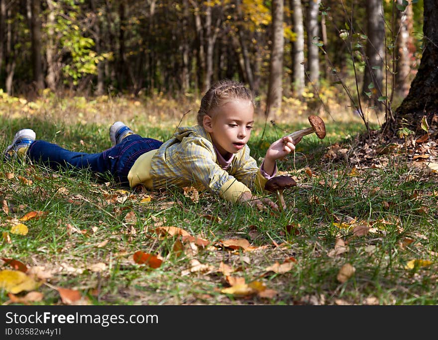 A girl is laying on a grass in the forest