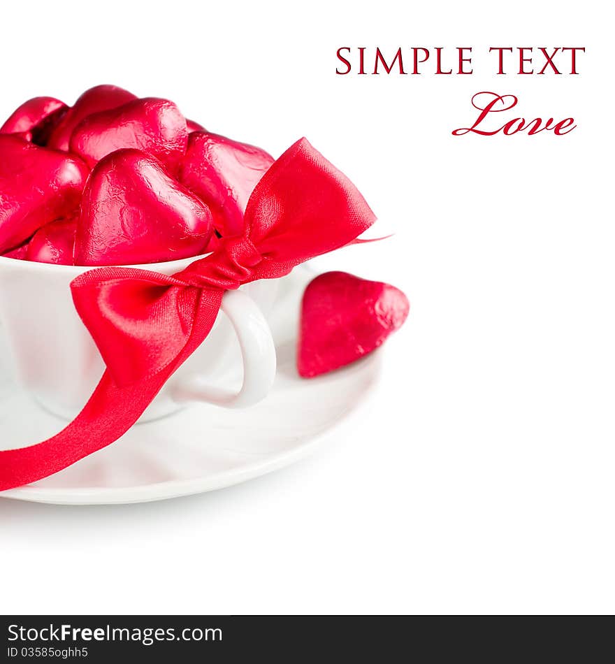 White cup with red chocolate hearts and ribbon with sample text. White cup with red chocolate hearts and ribbon with sample text