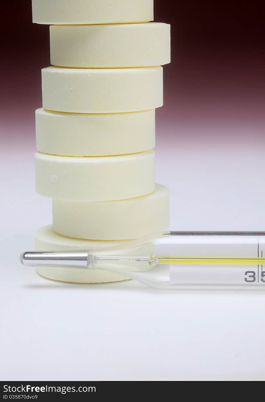 Close-up medical thermometer and pills